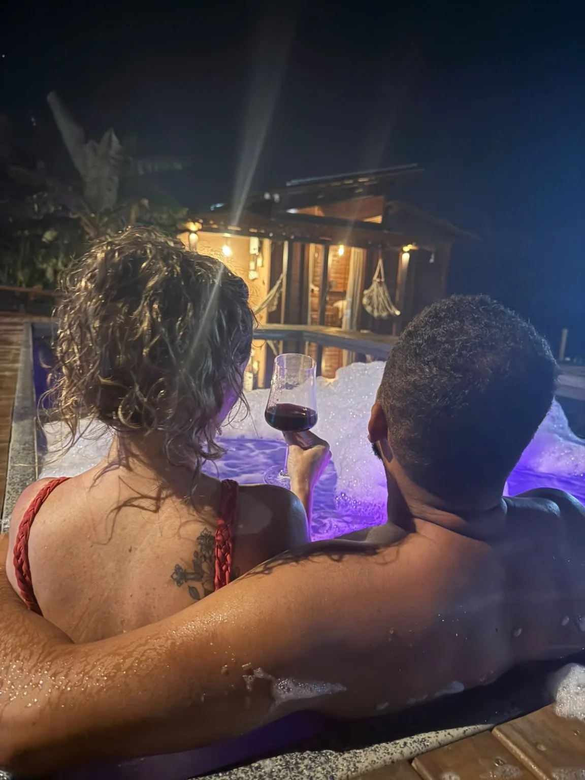 Ville Signature — casal no spa com o chalé ao fundo